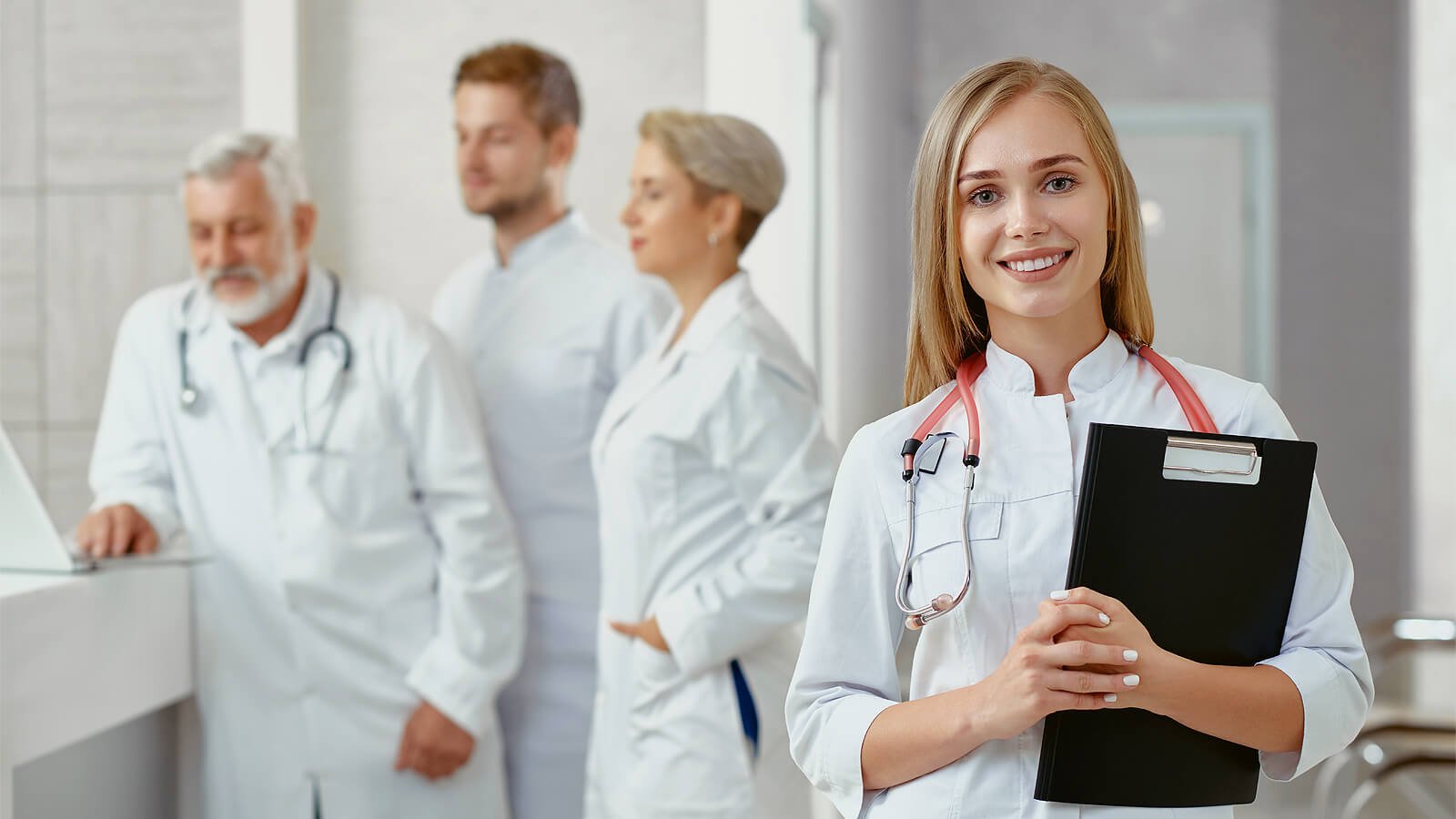 Lady doctor smiling and doctors working in the background